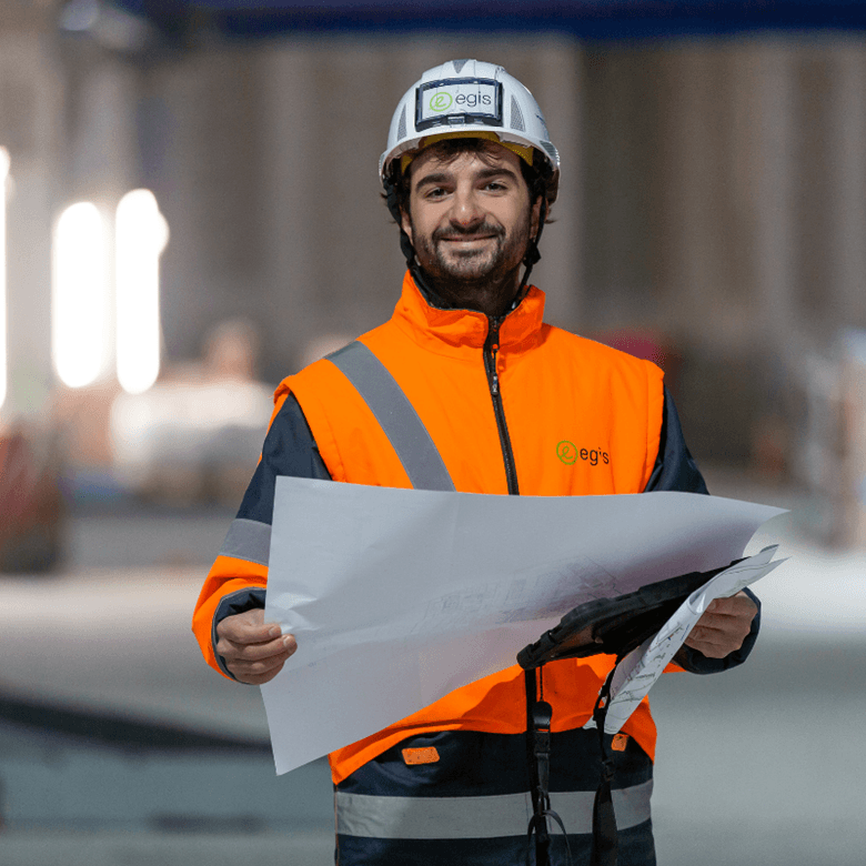 ©Studio Cabrelli Smiling Man On Site With Helmet And Map In Hand Safety And Security