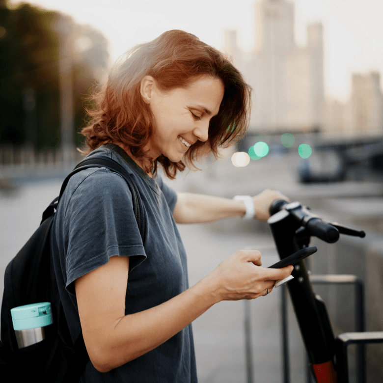 © Adobestock © Olezzo Young Happy Woman Renting Scooter Using Mobile App In Smartphone, Modern Transport In City
