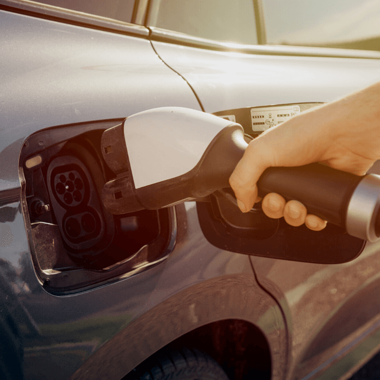 © Adobestock Ypavel Kašák Man Hand Is Holding Electric Car Charging Connect To Elecric Car On Charge Station, Electric Mobility Environment Friendly